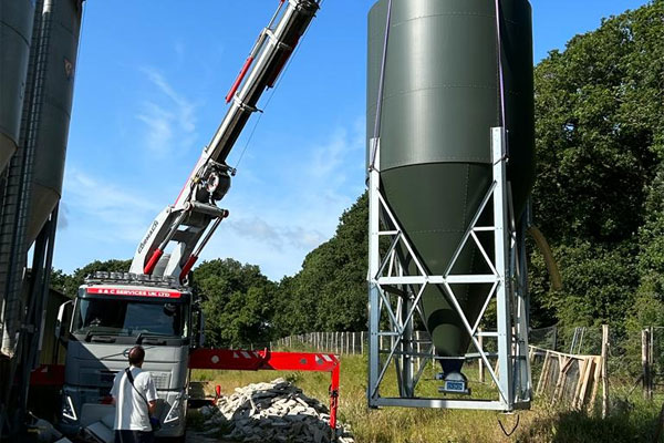 Crane lifting silo