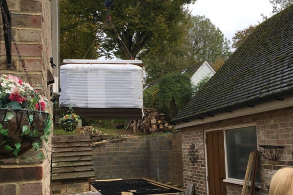 An image of us moving a hot tub into a clients back garden for them.